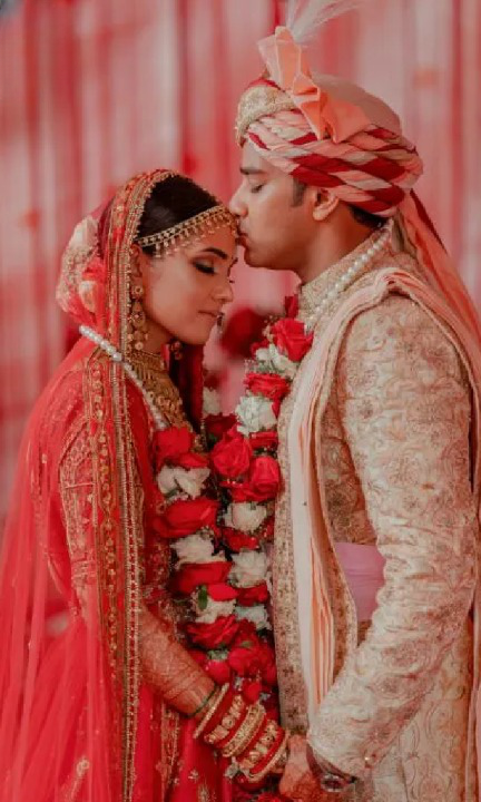 Our beautiful couple make a grand entrance on their big day with our  customized red bridal lehenga and ivory-gold accent groom sherwani!… |  Instagram