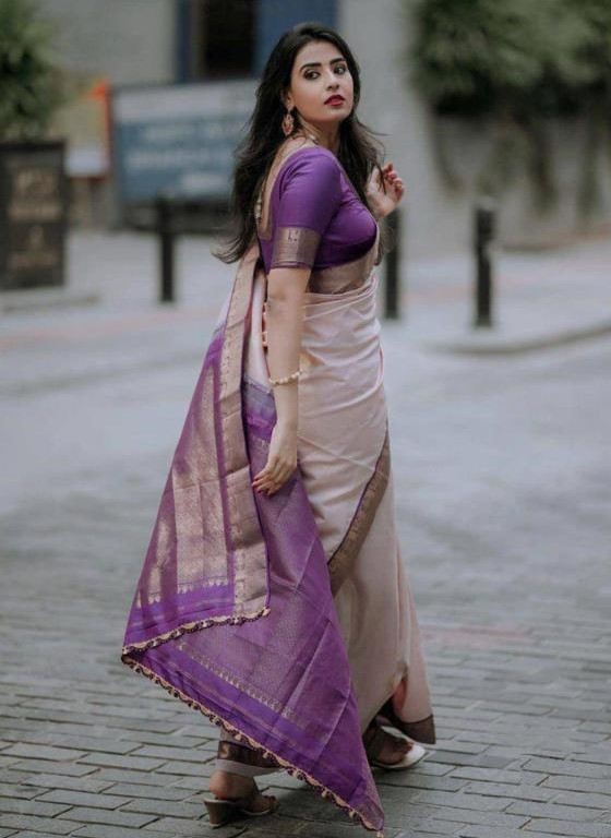 Elegant beige silk saree with vibrant purple border, perfect for weddings, receptions, and festive occasions, styled for a classic Indian bridal guest look.